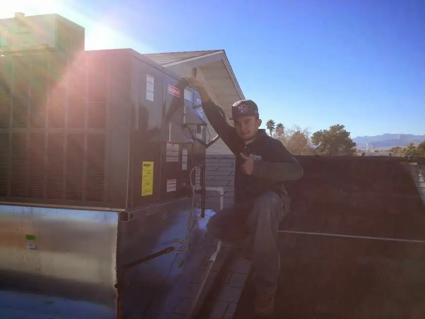 HVAC technician performing AC Tune-Up on a rooftop unit in Oregon